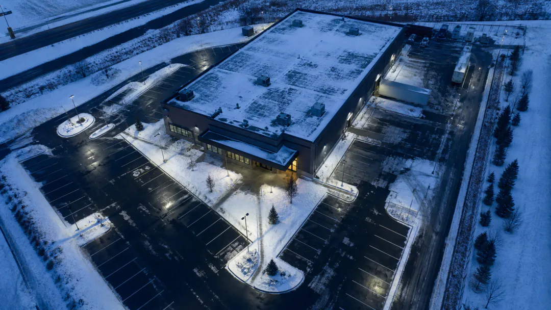 Aerial view of a commercial property showing entrances, parking, loading and perimeter snow areas